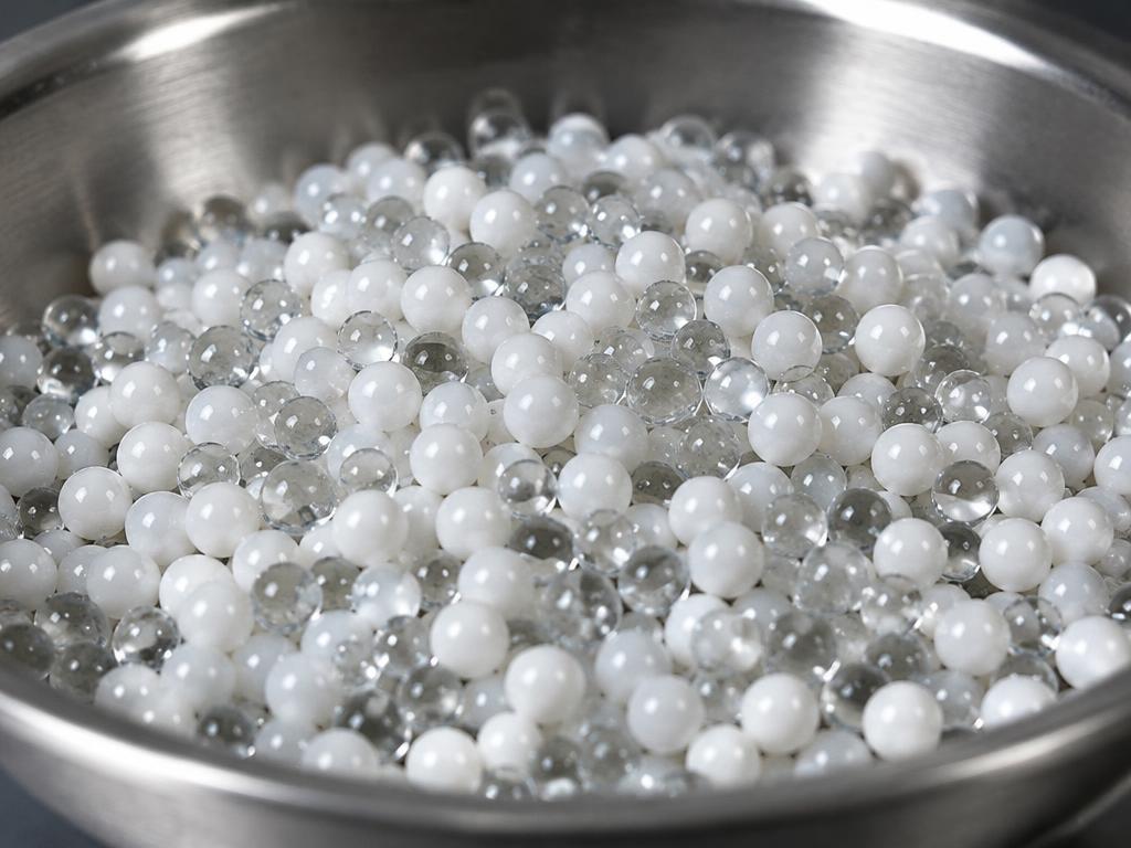Tiny glass and ceramic blasting beads in a steel dish